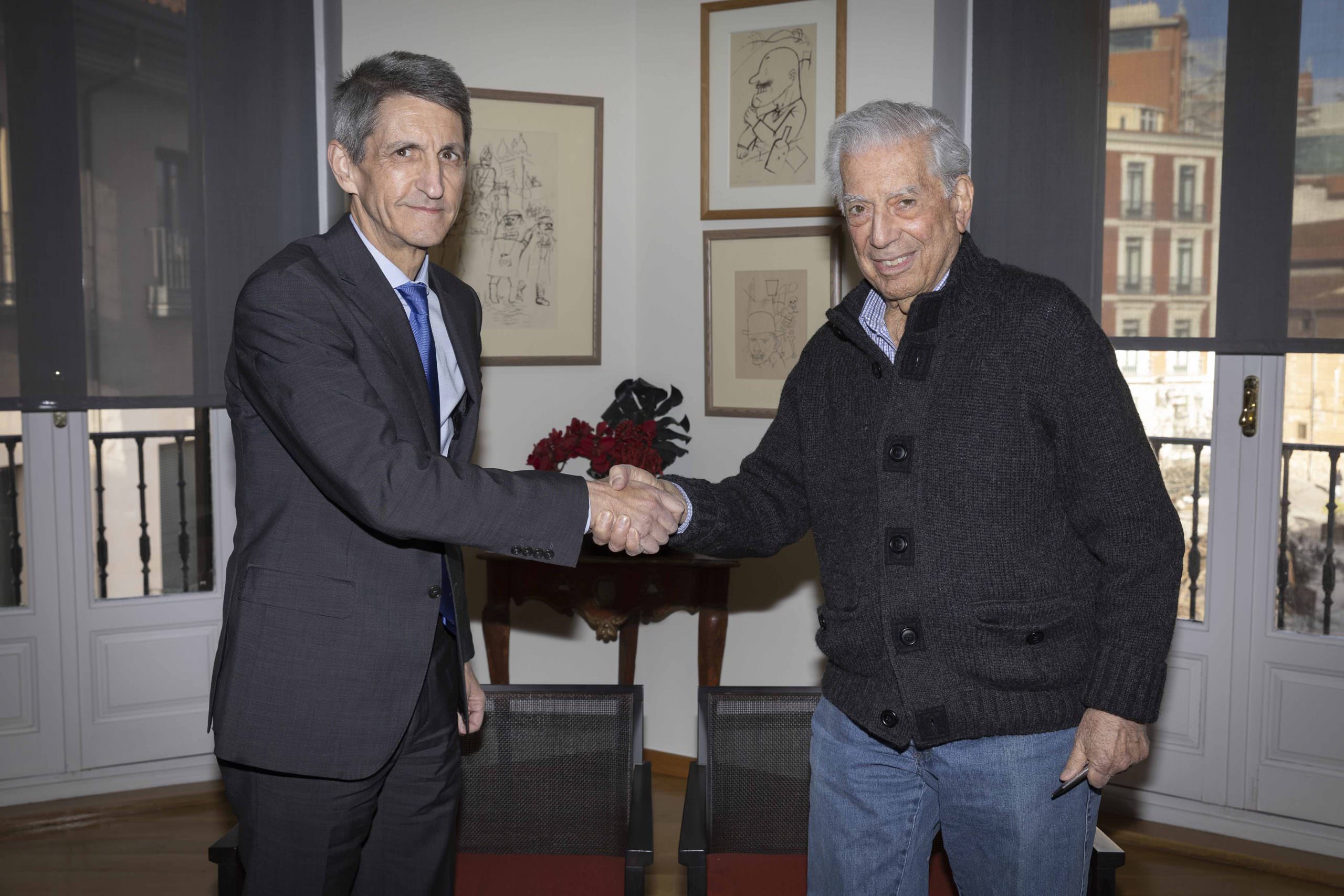 El presidente de la Fundación Bancaria Unicaja, José M. Domínguez, y Mario Vargas Llosa, presidente de la Cátedra Vargas Llosa, se estrechan la mano con motivo de la firma del convenio de colaboración